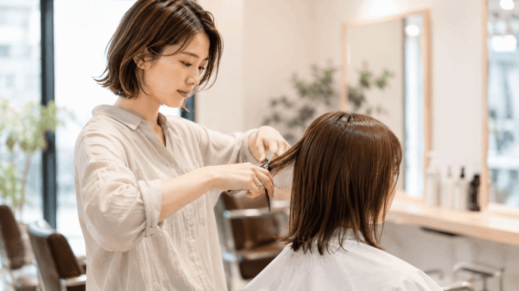美容室で顧客の髪を整えるフリーランス美容師